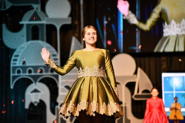 Una de las candidatas infantiles saluda a los foguerers y barraquers durante el desfile individual