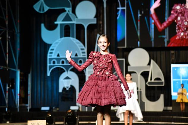 Una de las candidatas infantiles saluda a los foguerers y barraquers durante el desfile individual