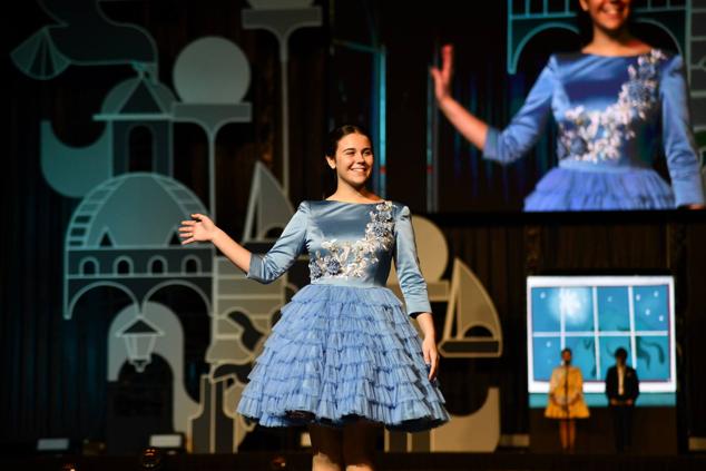 Una de las candidatas infantiles saluda a los foguerers y barraquers durante el desfile individual