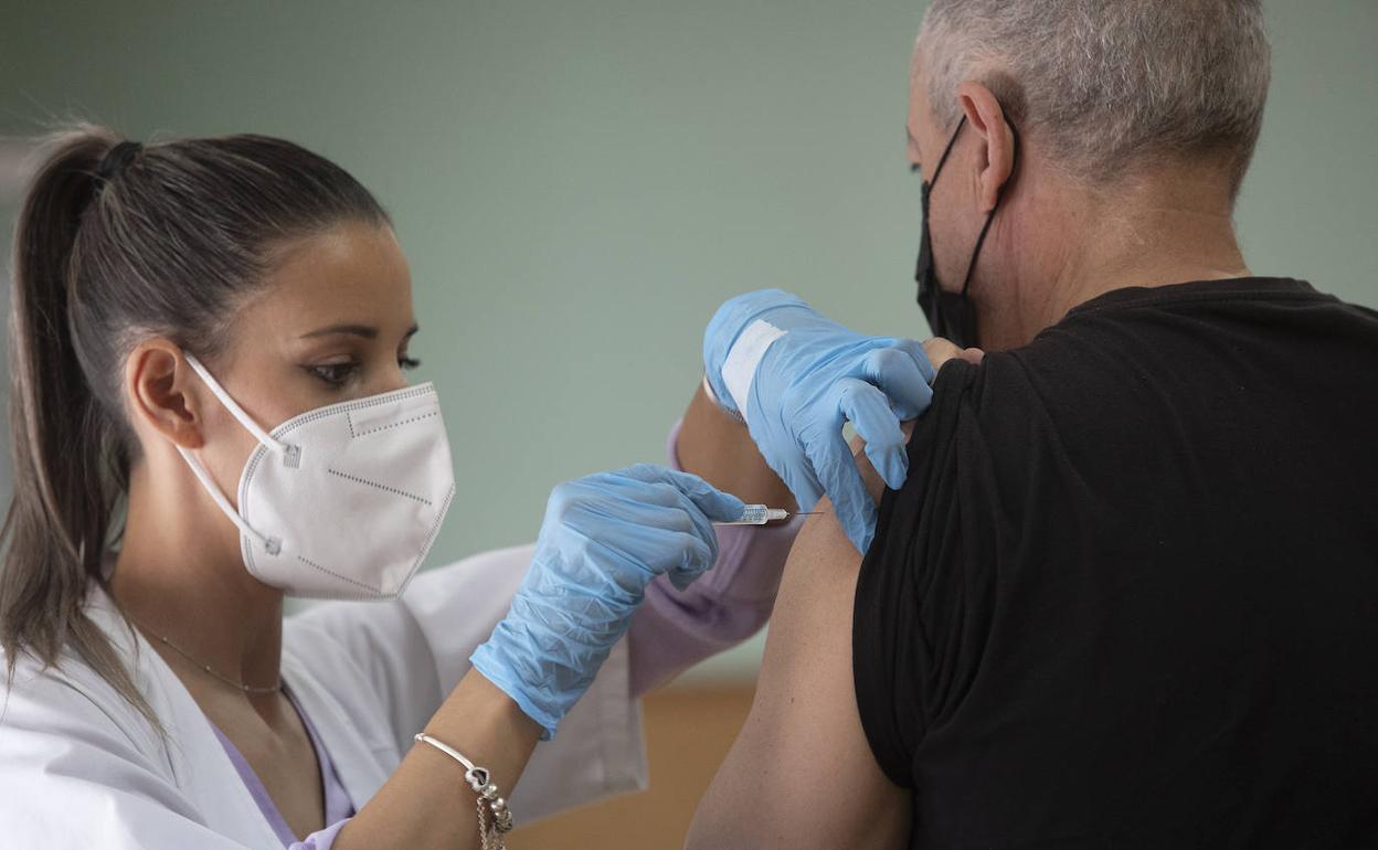 Sanitaria administrando una vacuna contra la covid. 