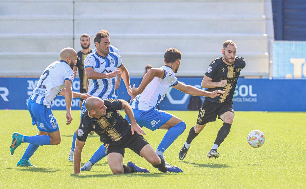 Cristian Herrera y Jon Etxaniz tratan de llevarse un balón ante varios rivales del Baleares. 