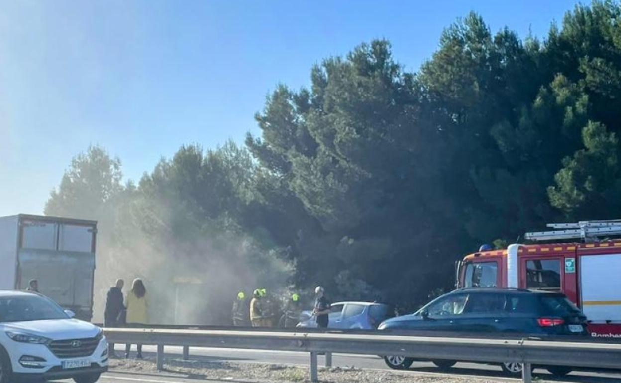 Los agentes durante la extición del fuego en el vehículo. 