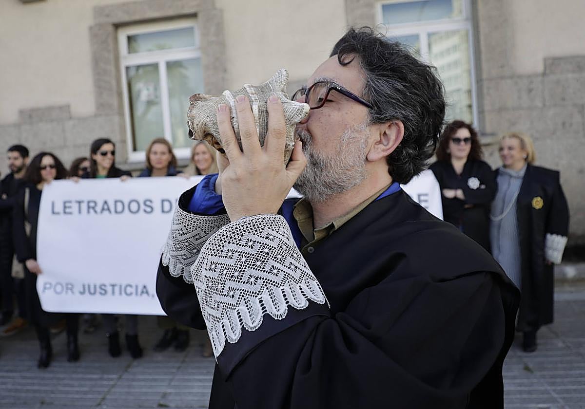 Un letrado hace sonar una caracola durante la concentración del colectivo de letrados de la Administración de Justicia
