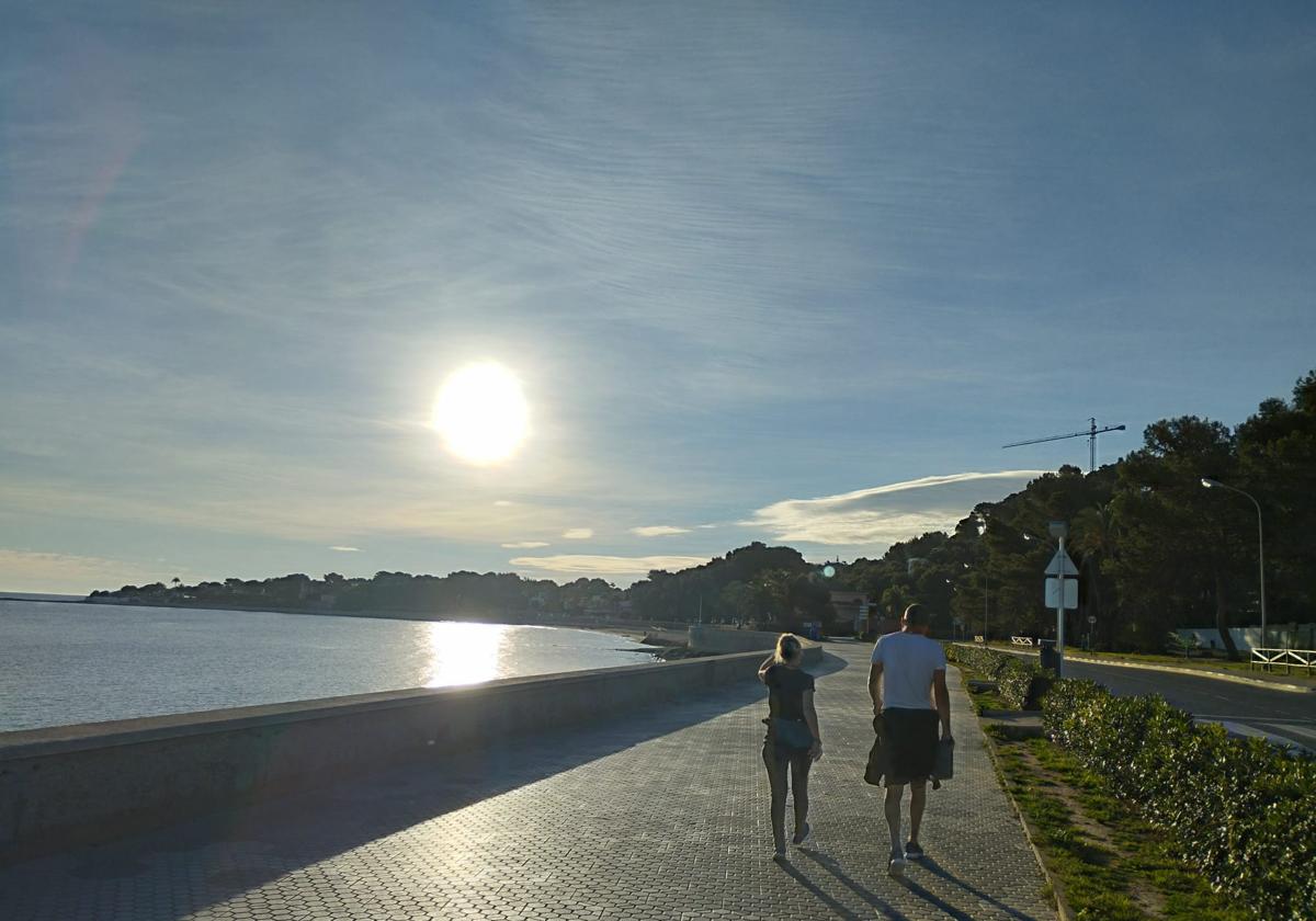 Una pareja pasea por el paseo de Dénia.