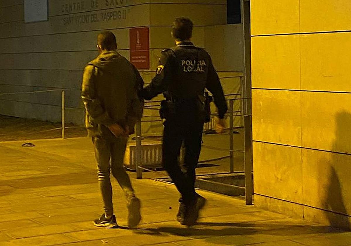 El detenido, custodiado por un agente.