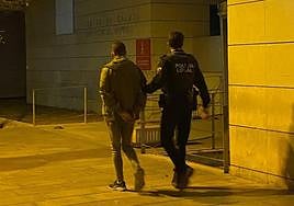 El detenido, custodiado por un agente.