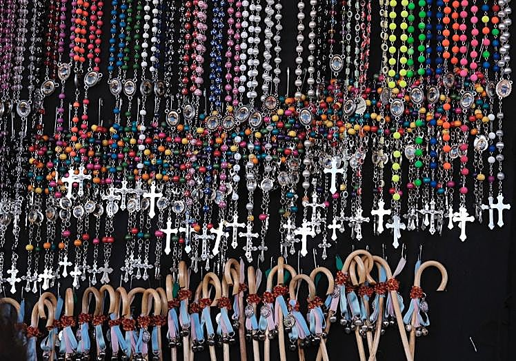 Imagen principal - Rosarios y medallas en los puestos del mercadillo