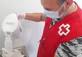 Un miembro de Cruz Roja prepara alimento para un bebé.