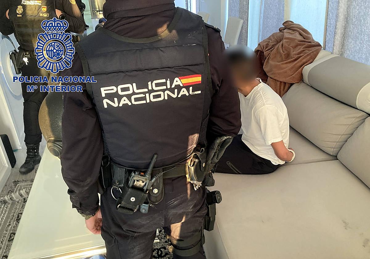 Uno de los agentes junto al detenido durante la intervención