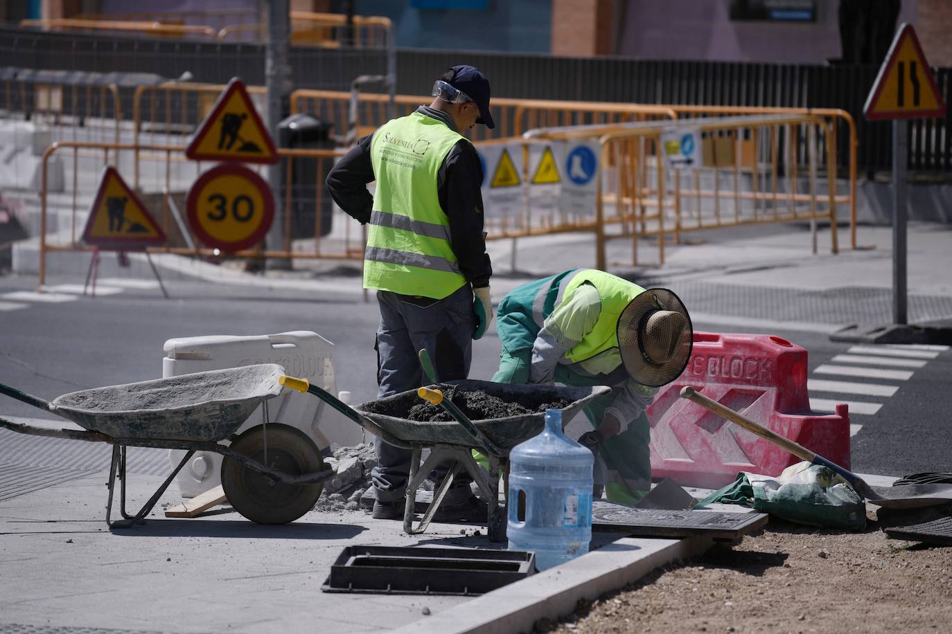 Operarios trabajando en una obra a pie de calle.