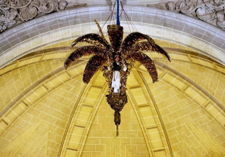 La 'Magrana' baja de la cúpula central de la Basílica de Santa María con un ángel cantando en su interior durante la representación del Misteri de Elche.