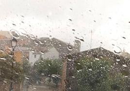 Un conductor dentro de un coche conduciendo bajo la lluvia