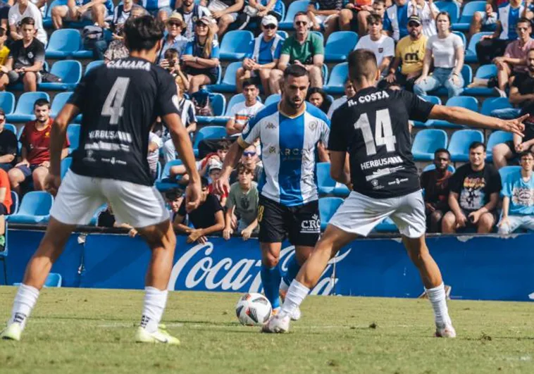 Ander Vitoria, entre dos jugadores de la Peña Deportiva en el Rico Pérez