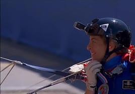 Primer salto de una mujer paracaidista con la bandera de España en un desfile de las Fuerzas Armadas.