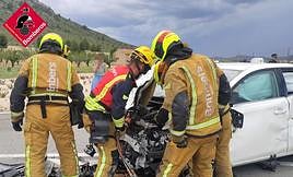 Los bomberos excarcelan a uno de los heridos en el siniestro.