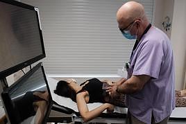 El doctor José Bañuls analiza el lunar de una paciente en su consulta.