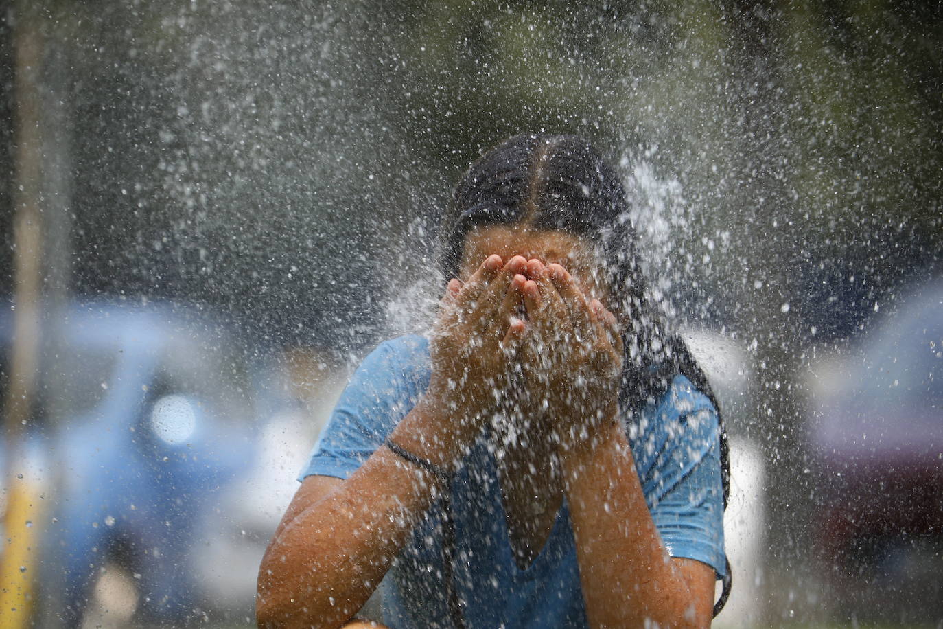 Una mujer se refresca con agua ante el calor sofocante.