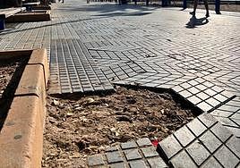 Un trozo de pavimento levantado en el paseo de la playa del Postiguet