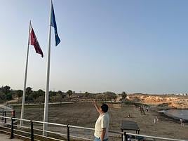 El concejal Manuel Mestre señala la bandera que ha vuelto a ondear en Cala Mosca.