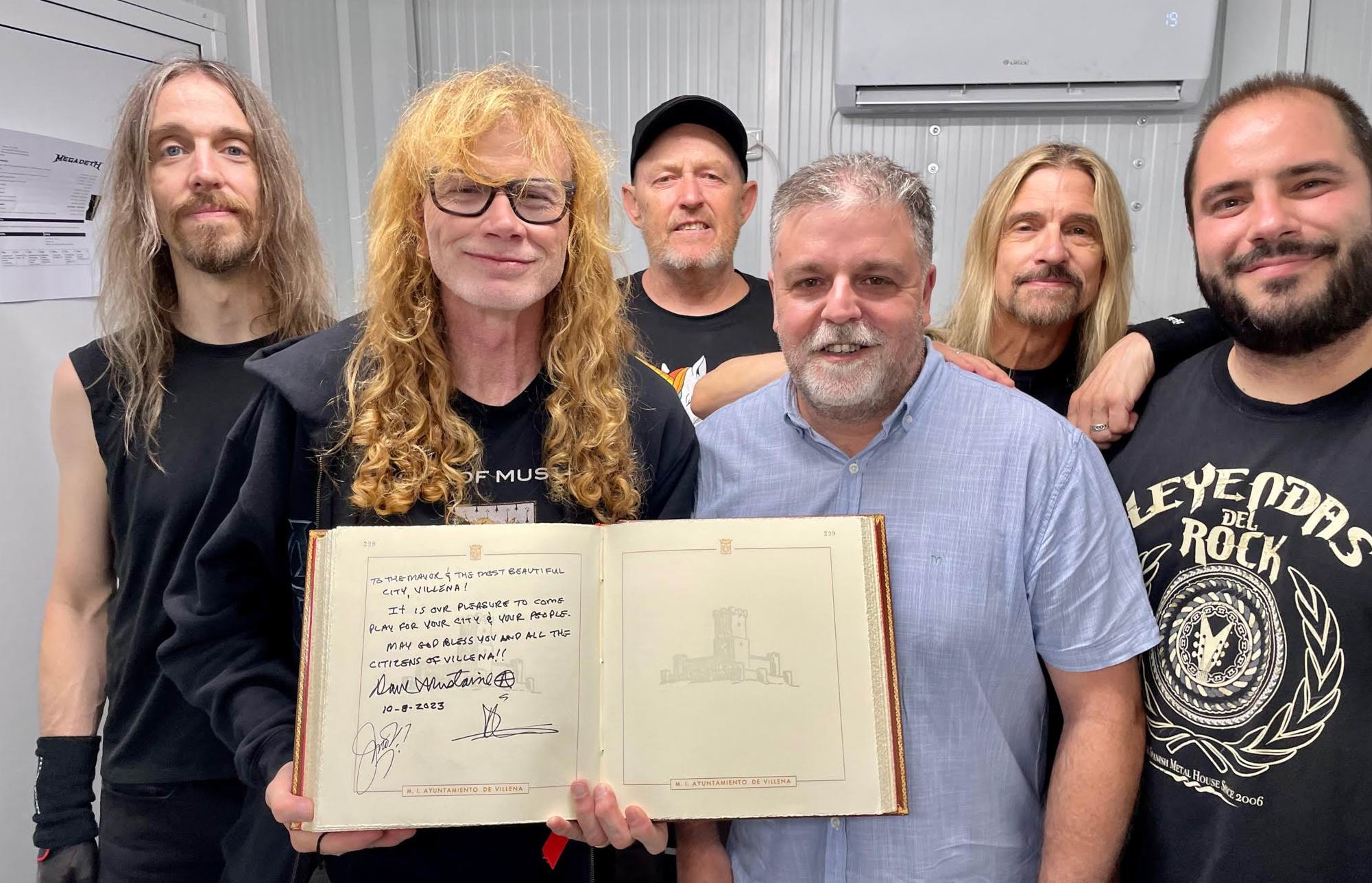 Mustaine sostiene el libro de firmas acompañado por el alcalde de Villena.