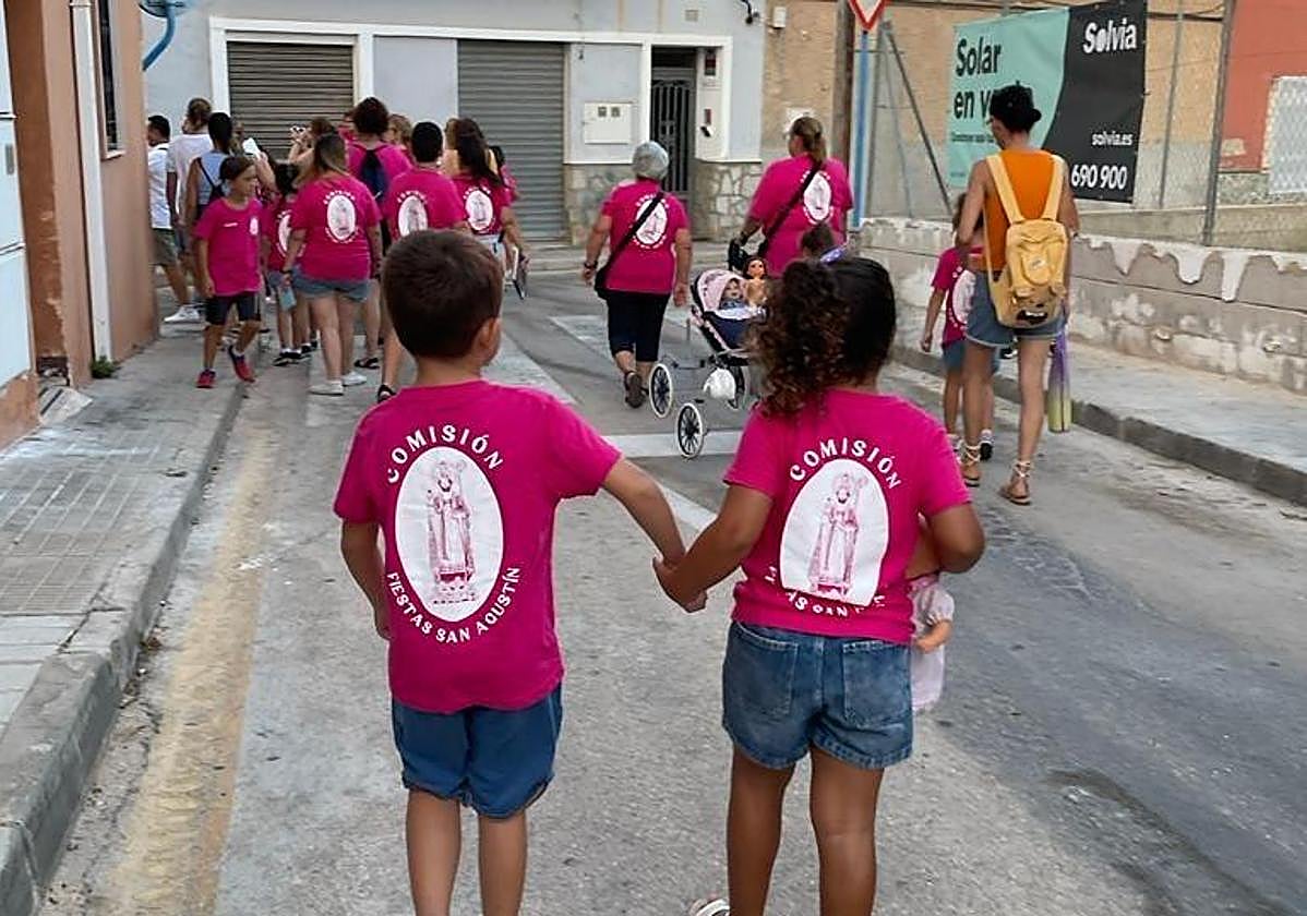 La comisión de fiestas de San Agustín reparte llibrets por el barrio.