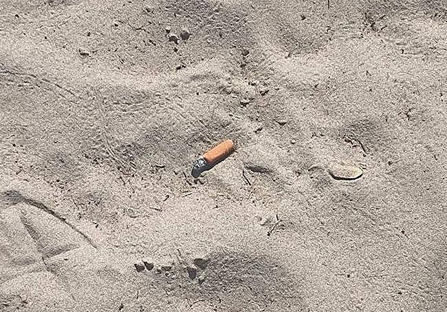 Una colilla en la arena de la playa del Postiguet.