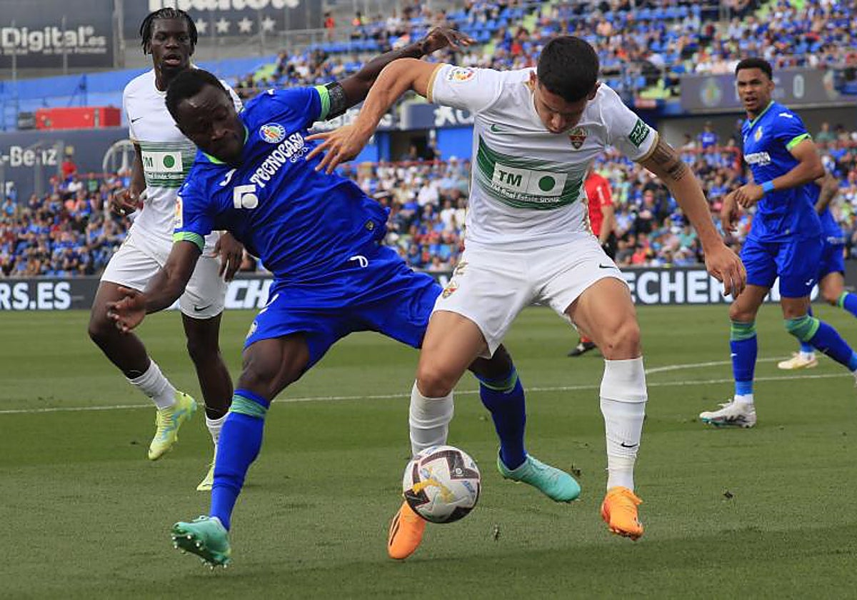 Lautaro Blanco protege el balón ante Djené la temporada pasada