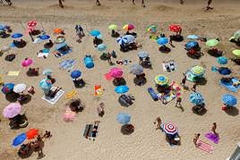 Decenas de turistas disfrutan en la playa de Benidorm.