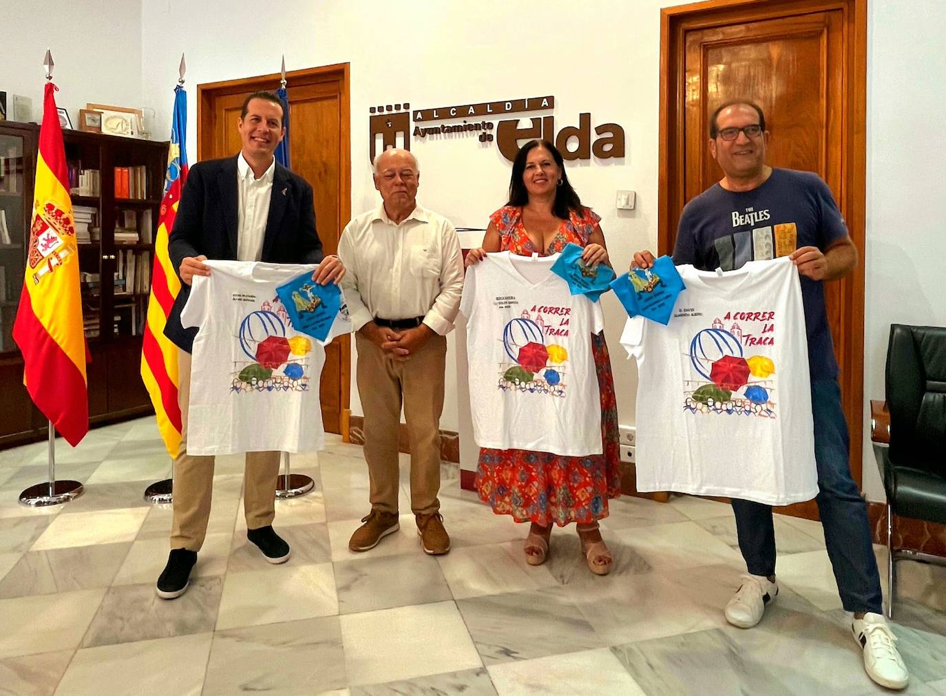 Rubén Alfaro, alcalde de Elda, David Guardiola, concejal de Fiestas, y Loli Soler, pregonera de las fiestas, reciben la camiseta y el pañuelo para 'correr la traca'