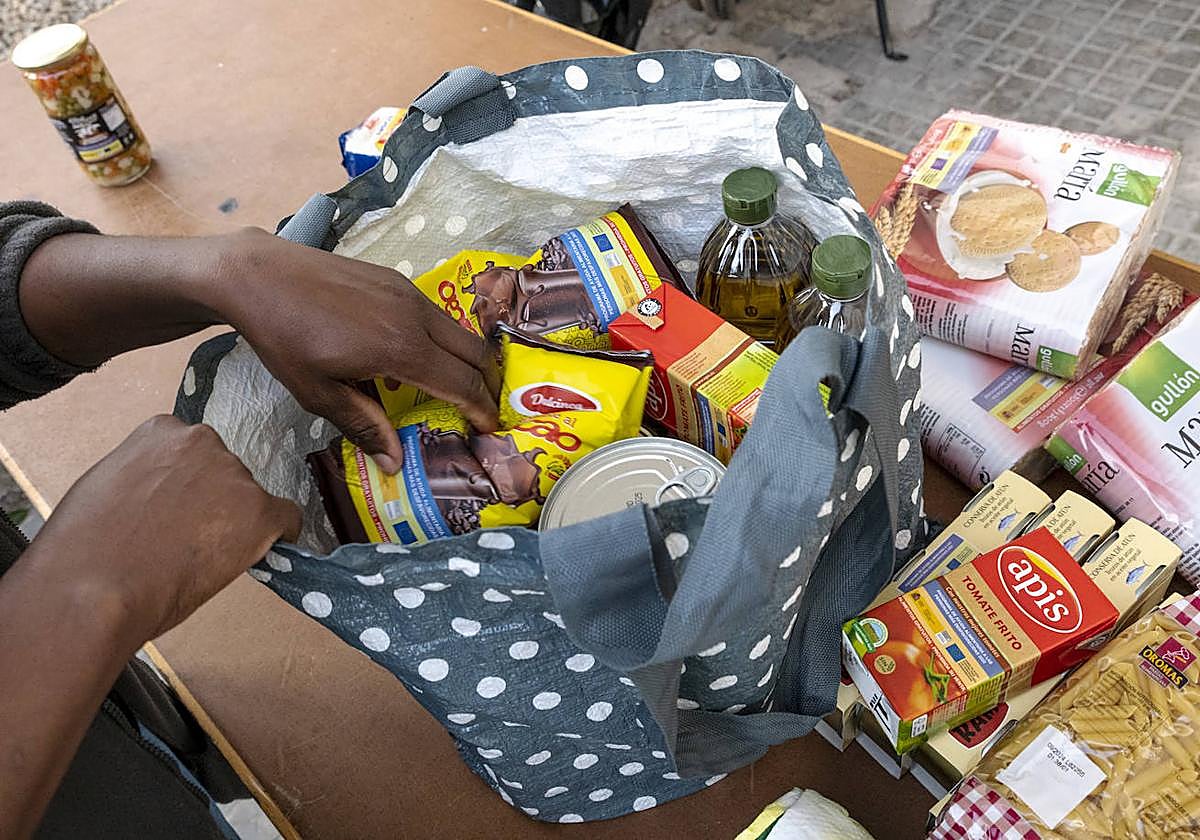 Una persona recibe comida de un banco de alimentos.