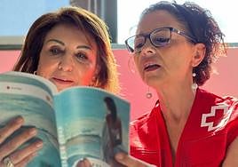 Remedios Alarcón, presidenta local de Cruz Roja, junto a una voluntaria con 'Trazos de Vidas'.