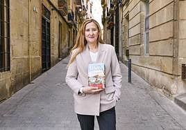 La escritora Luz Gabás con su novela en el casco antiguo de Alicante.