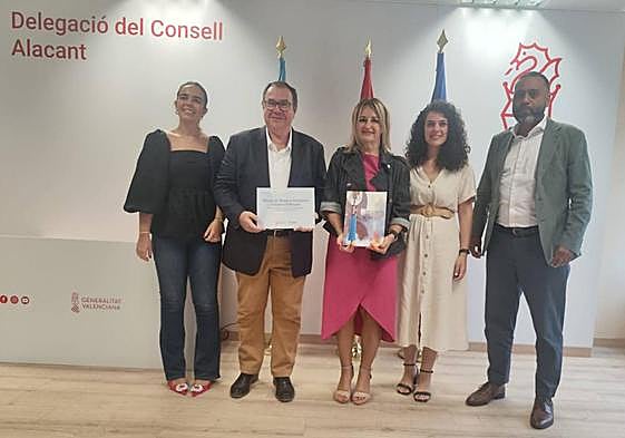 La consellera de Turismo, Nuria Montes, entrega la distinción a los Moros y Cristianos de San Blas, en compañía de la concejal de Fiestas, Cristina Cutanda.