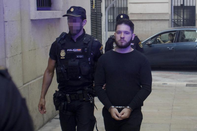 Dos agentes de la Policia Nacional escoltan al acusado antes del juicio.