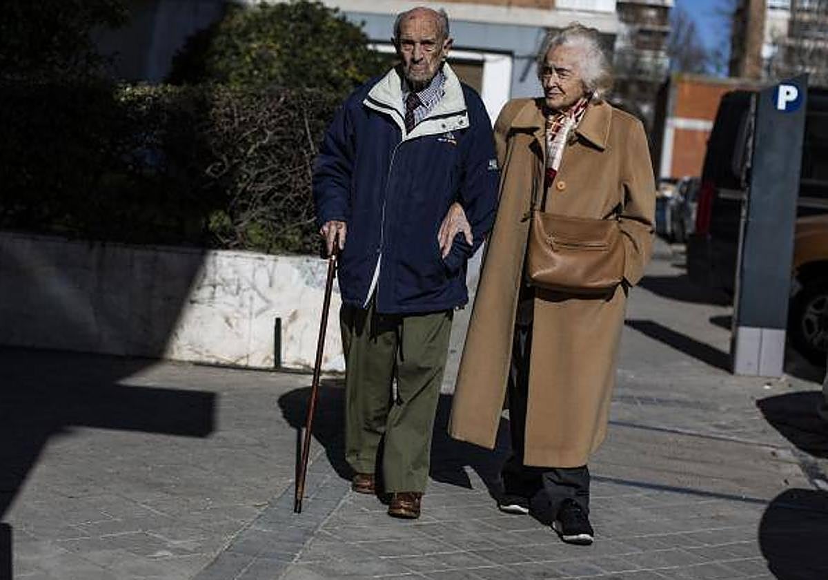 Una pareja de pensionistas, caminando por la calle.
