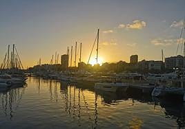 El sol se posa por el puerto de Alicante.