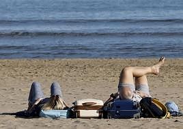 Dos personas disfrutan del buen tiempo en la playa.