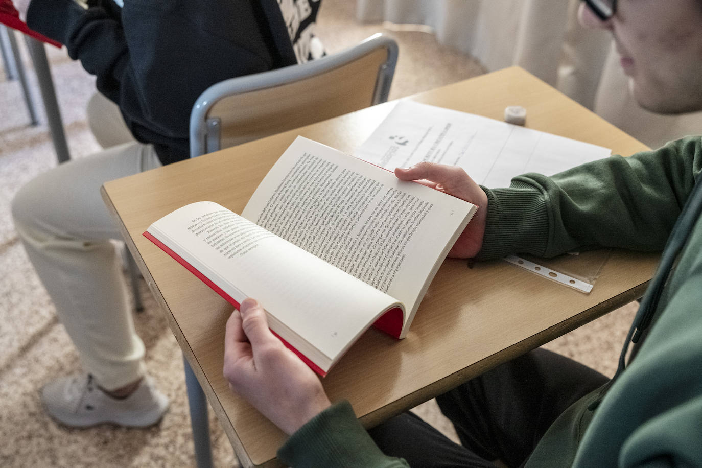 Alumno abre un libro en una aula de Alicante.