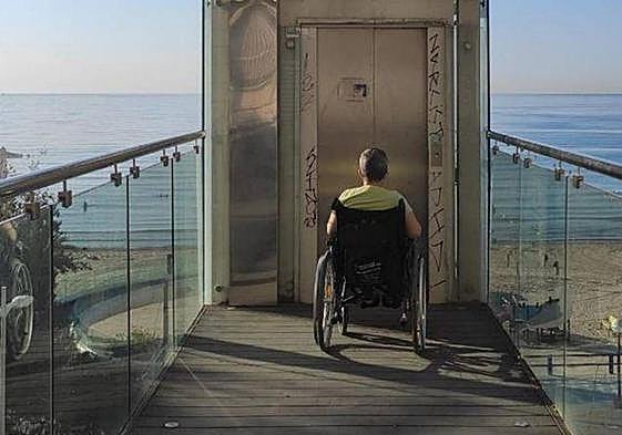 Una persona en silla de ruedas intenta acceder al ascensor.