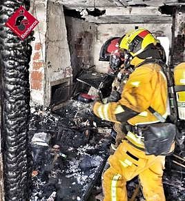 Los Bomberos, en una vivienda incendiada.