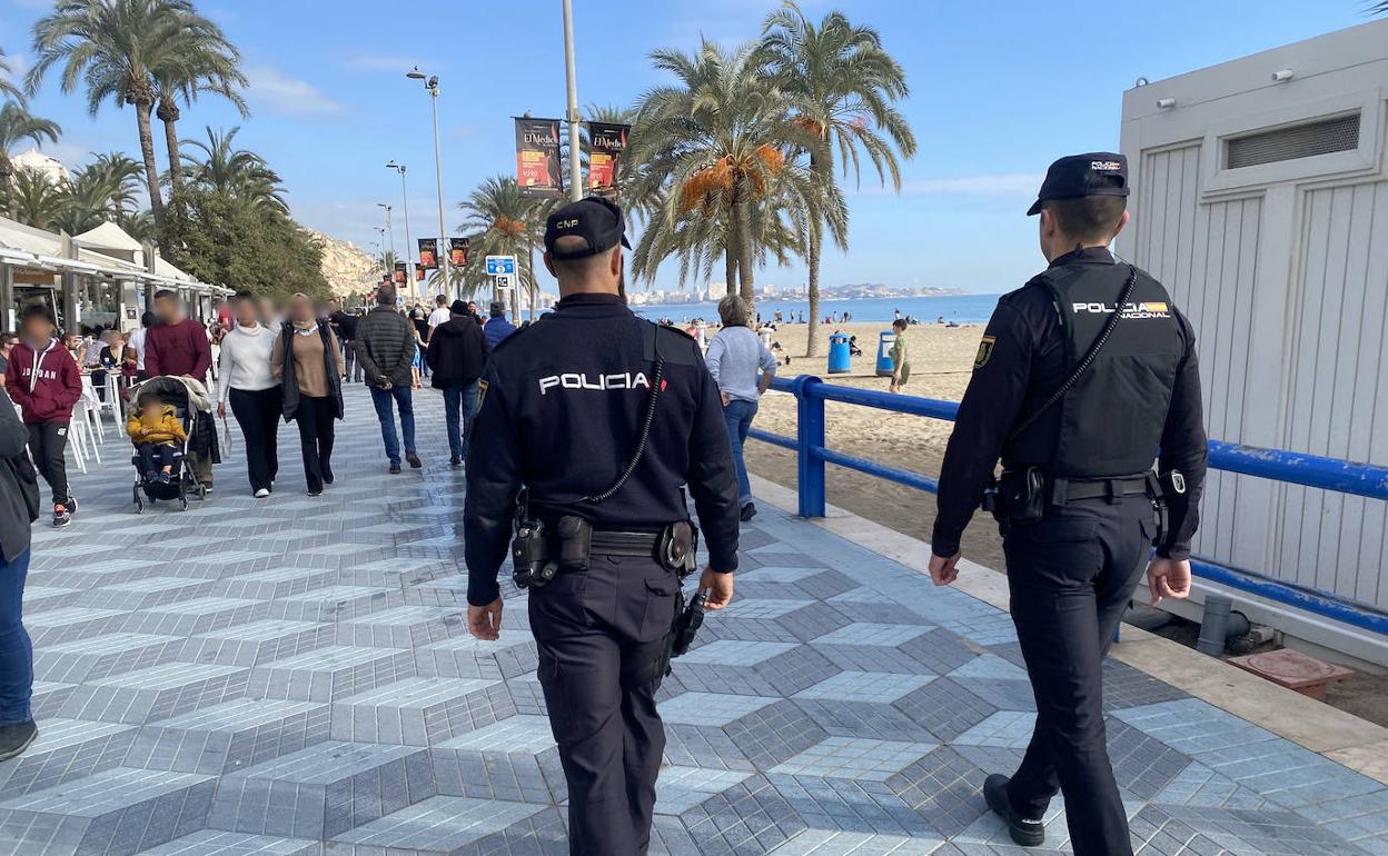 Dos agentes de la Policía Nacional patrullan la playa del Postiguet durante las fiestas navideñas