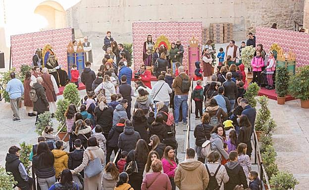 Niños y niñas con sus familias haciendo cola para hablar con los Reyes Magos. 