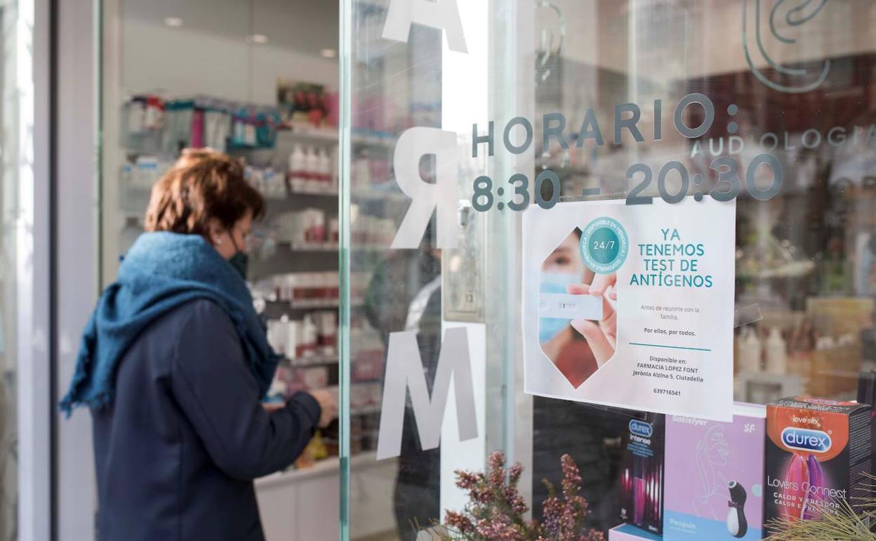 Una mujer frente a una farmacia, en imagen de archivo.