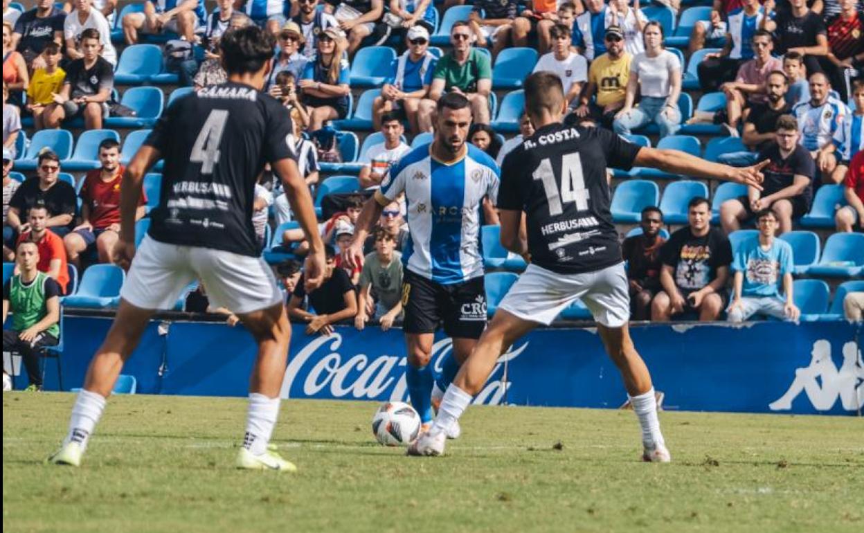 Ander Vitoria, entre dos jugadores del Peña Deportiva 