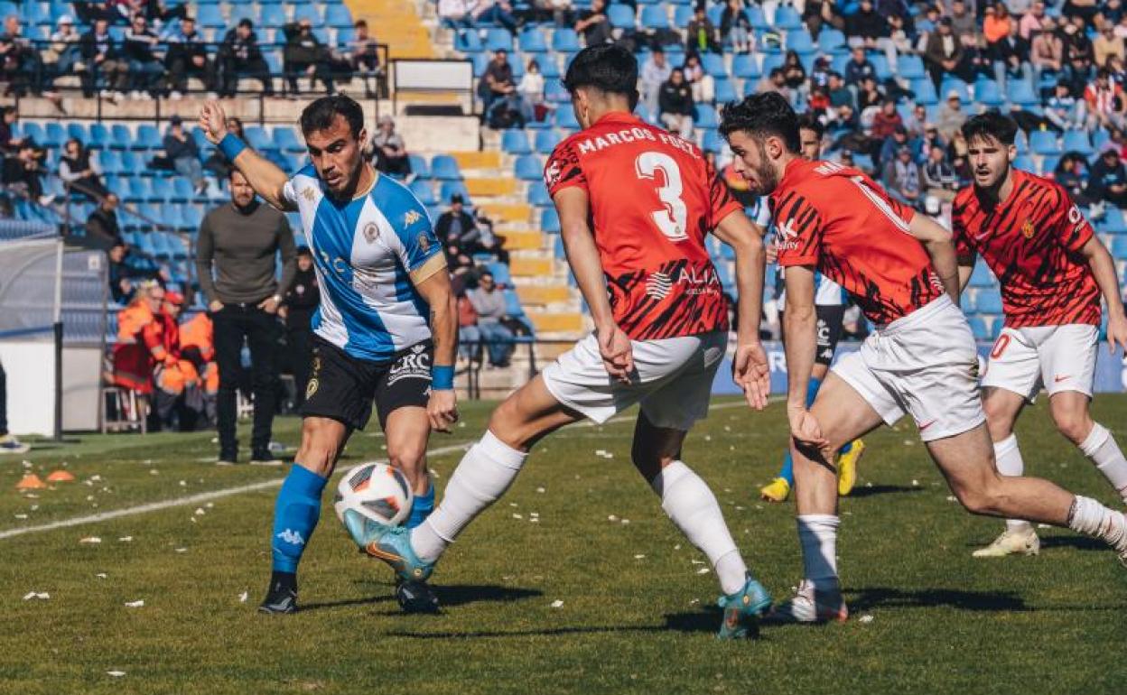 El argentino Maxi Ribero busca línea de pase ante dos jugadores del Mallorca B 