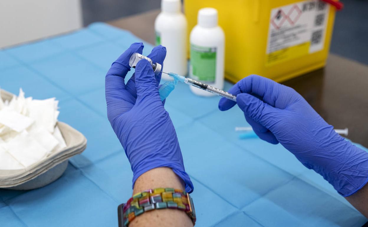Una sanitaria sostiene una dosis de la vacuna contra el covid 