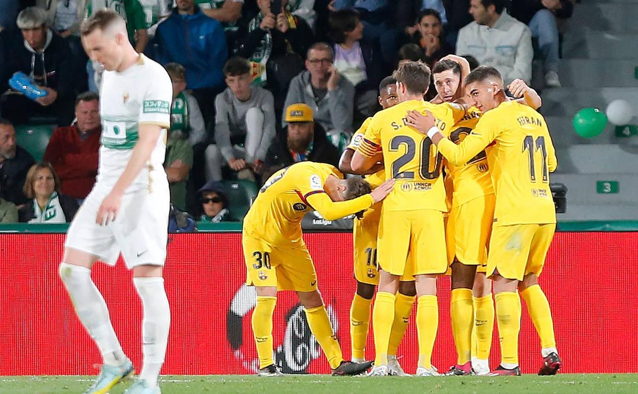 Los jugadores del Barcelona abrazan a Lewandowski tras anotar el primer tanto del partido. 