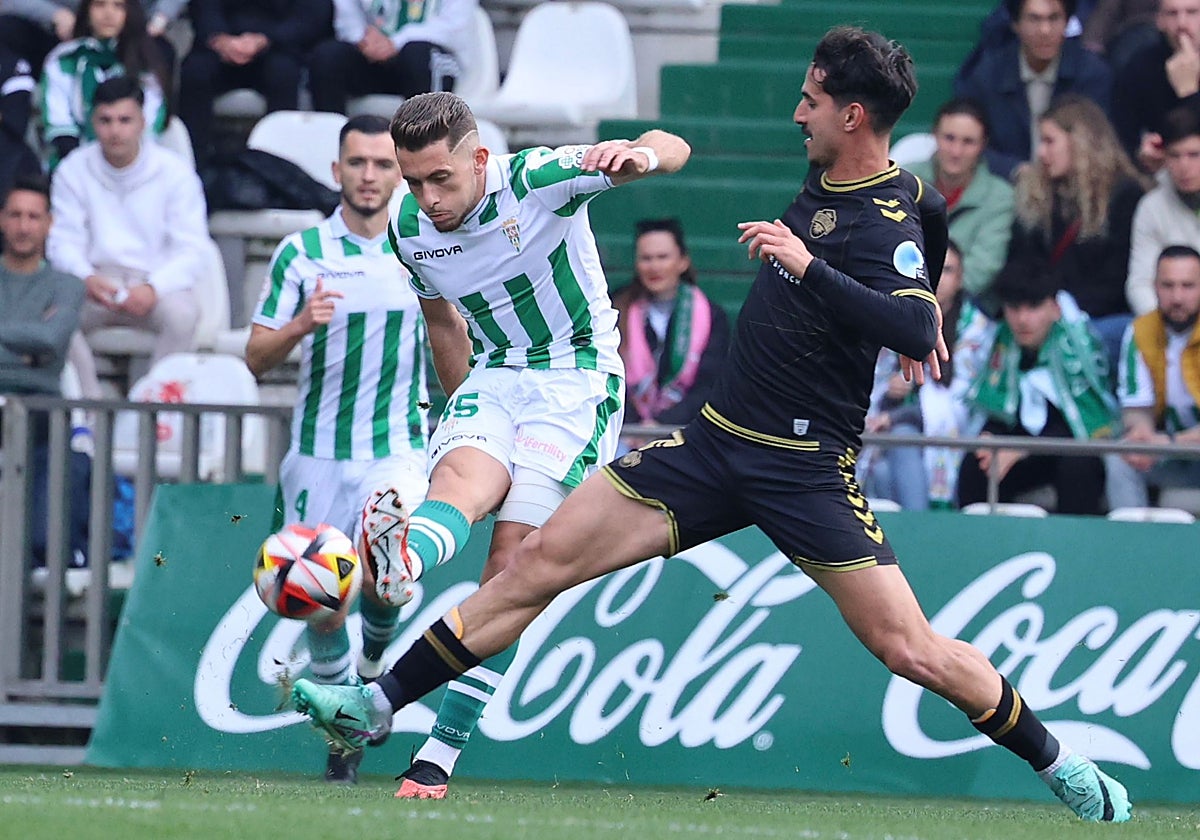El centrocampista del Córdoba Isma Ruiz da un pase ante la presión del jugador del Intercity Soldevila.