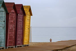 Un hombre se baña en la playa de San Juan a pesar de la fina lluvia que caía este viernes.