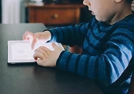 Un menor haciendo uso de una tableta electrónica.